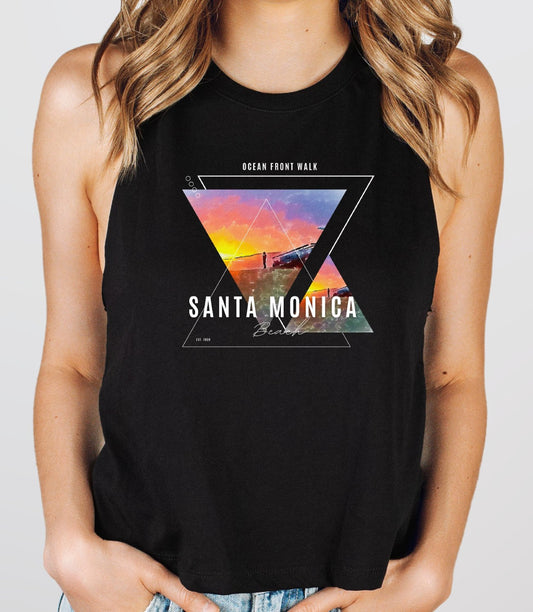 Infuse your summer wardrobe with a touch of romance and nostalgia with our chic cropped tank, featuring the iconic Santa Monica Beach Pier at sunset. This enchanting piece beautifully captures the vibrant colors and serene beauty of the California coast, evoking memories of dreamy beach days and golden evenings.